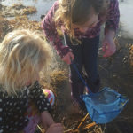 two girls marsh mucking