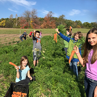 Kids help grow food for donation at Twin Villages Foodbank Farm