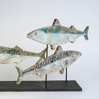 painted wooden sculpture of three mackerel