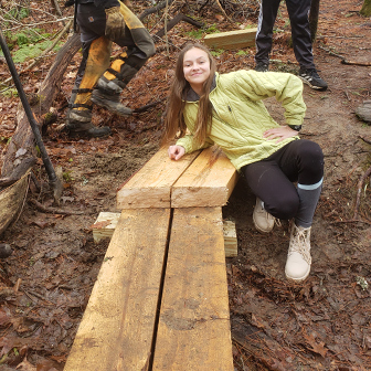 GSB student poses on the new trail bridge