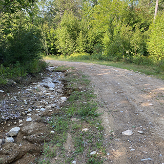 gravel road with eroding ditch