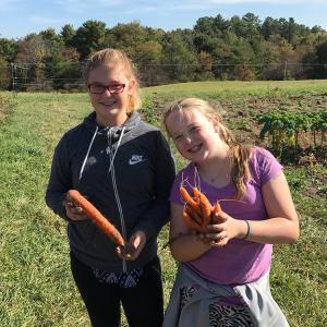 two girls posing with carrots
